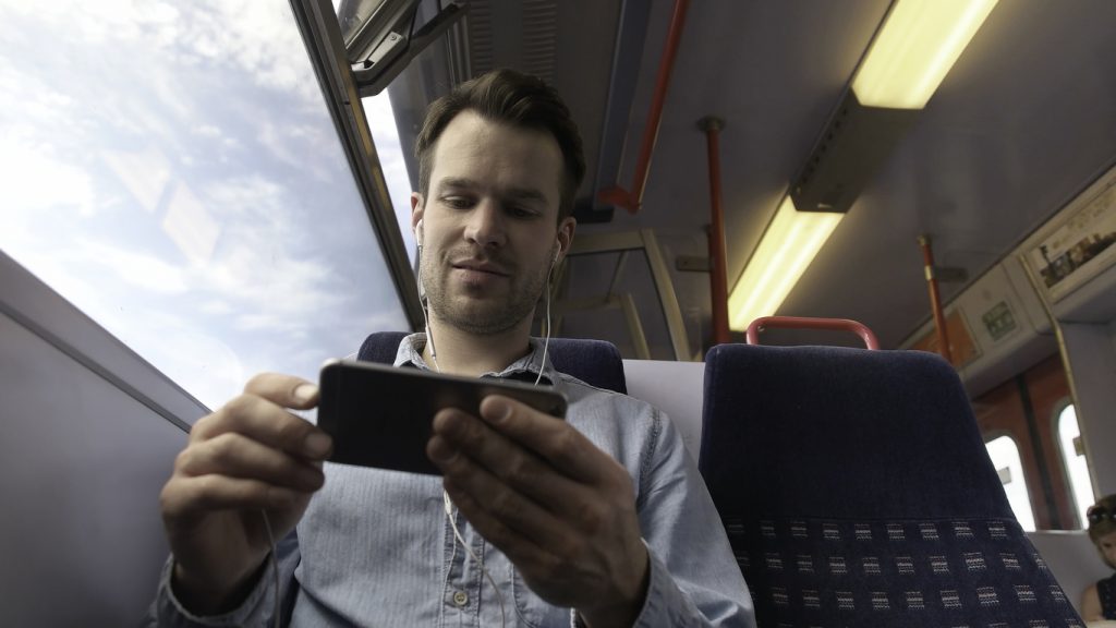 Man looking at his phone on a train