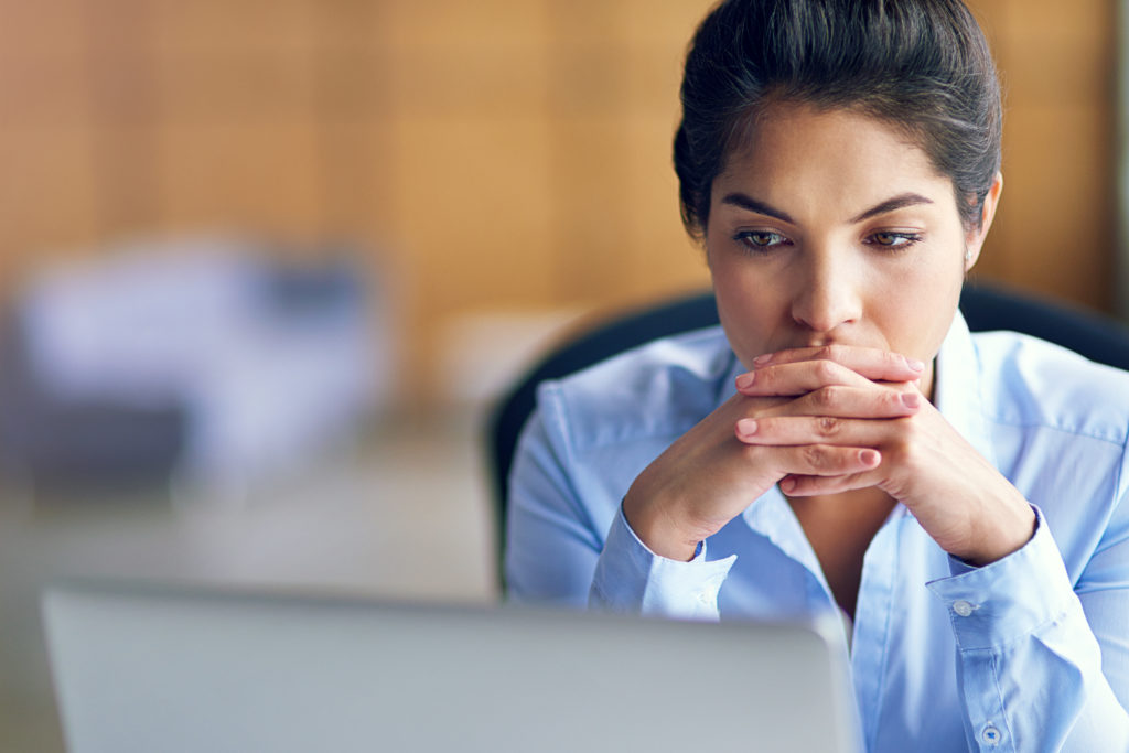 Business woman contemplating while viewing a laptop